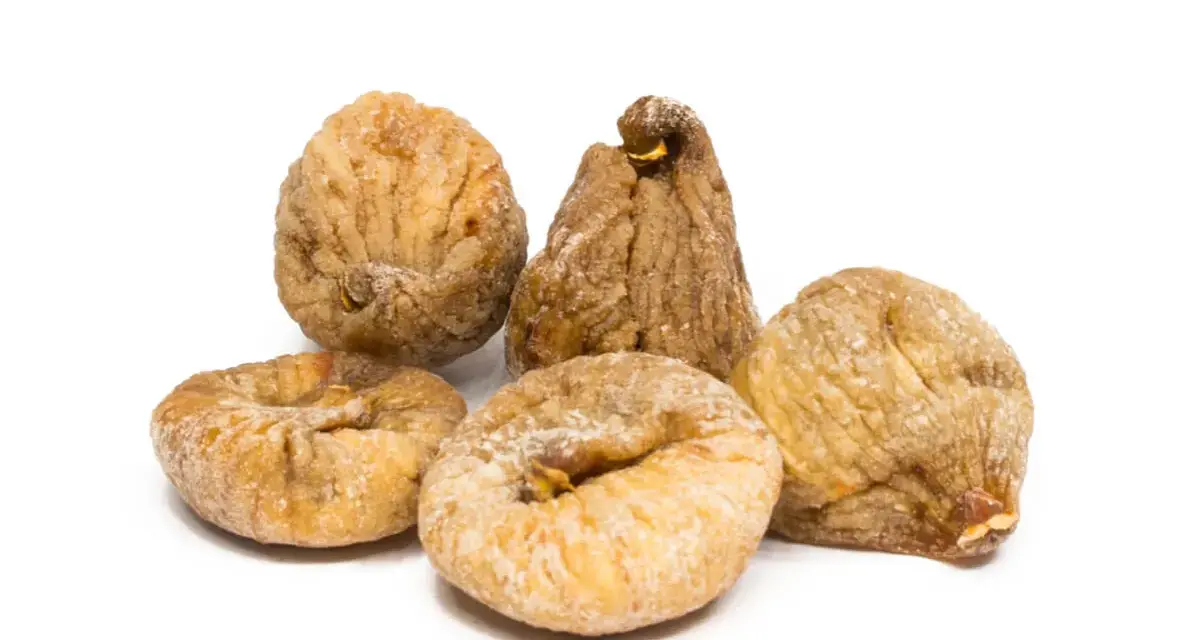 Fünf getrocknete Feigen, die zeigen, wie gesund Feigen sind. Sie sind leicht mit Zucker bestäubt und liegen auf weißem Hintergrund.