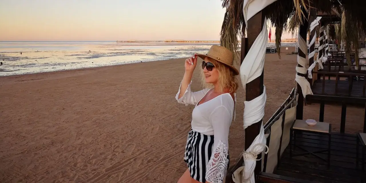 Kobieta w kapeluszu i okularach przeciwsłonecznych na plaży w Hurghadzie. Czy w Hurghadzie jest bezpiecznie? Tak, wygląda na to, że tak!