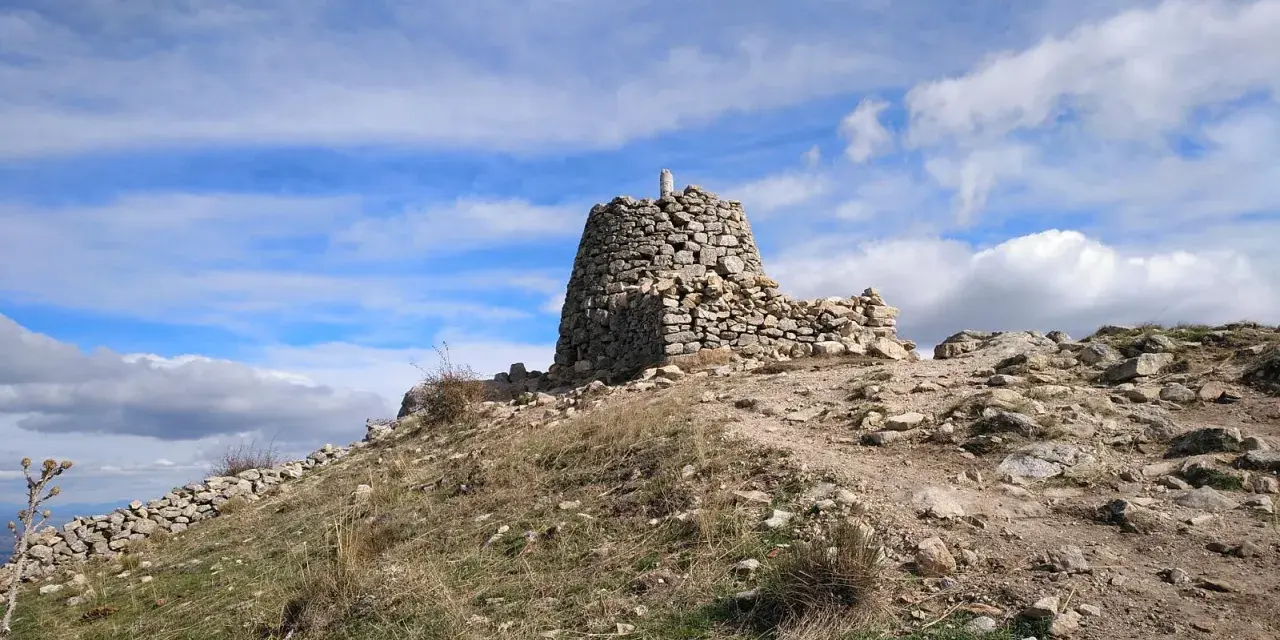 Ruinas de piedra en la cima del **cerro de San Pedro**, bajo un cielo azul con nubes blancas.