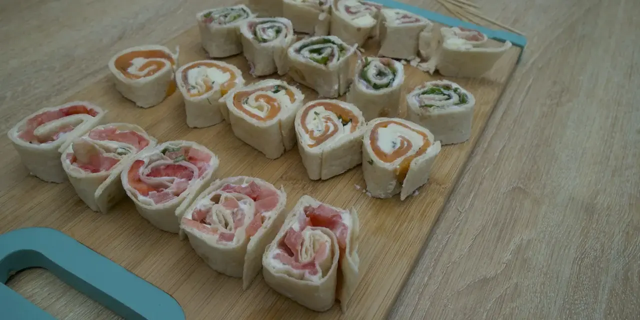 Petits roulés de wrap froid, parfaits pour un apéritif facile. Saumon, fromage frais et herbes se marient à merveille dans cette recette.