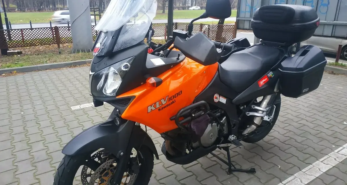 Pomarańczowy motocykl turystyczny Kawasaki KLV 1000 z kuframi, gotowy na przygodę.