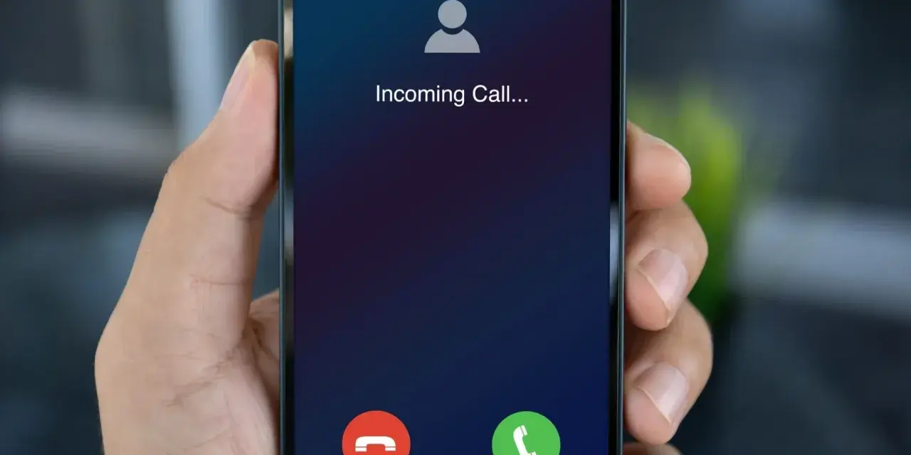 Dłoń trzyma smartfon z ekranem "Incoming Call...". Czy to połączenie z zagranicy, gdy działa co to roaming?