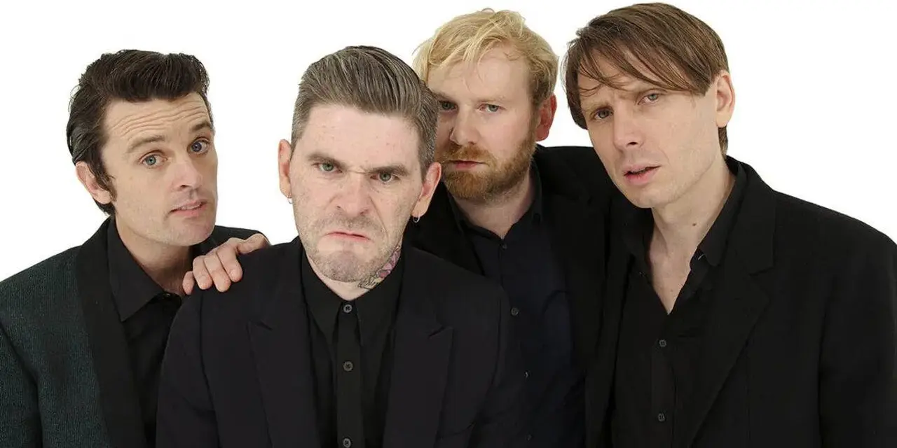 Les membres de Franz Ferdinand posent ensemble, quatre hommes aux regards intenses et aux coiffures stylées, prêts à enflammer la scène.