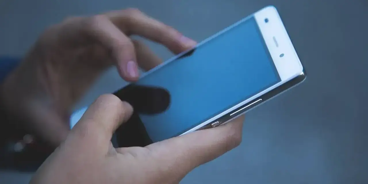 Dłonie trzymają smartfon, który może posłużyć jako telefon jako dowód w sprawie.