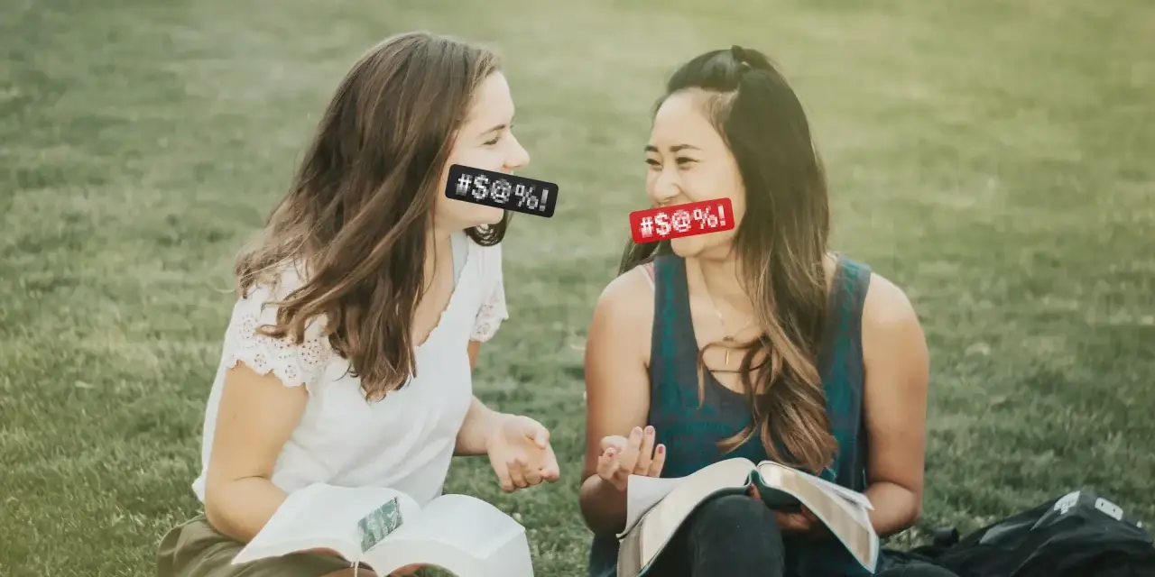 Two women with censored mouths discuss if cursing is a sin while reading books on the grass.