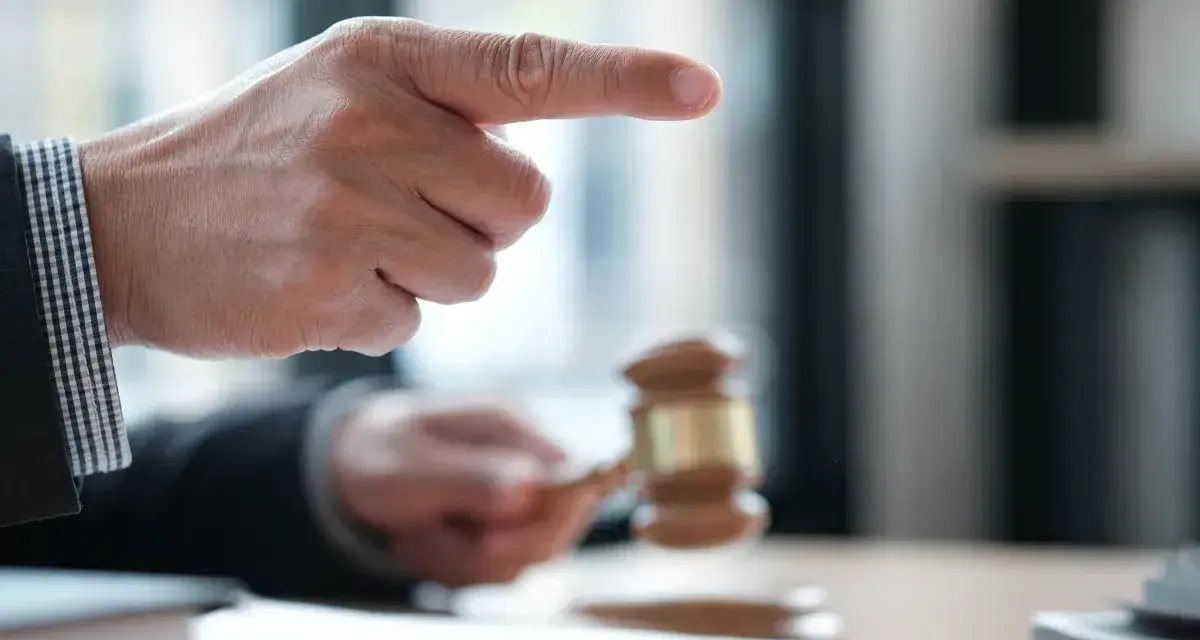 Sędzia wskazuje palcem, młotek sądowy w dłoni. Sprawa dotyczy śmierci wierzyciela a dług.