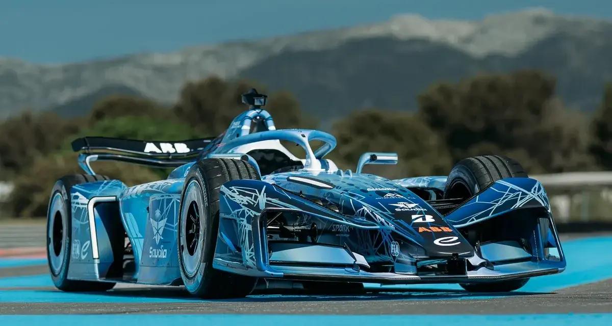 Coche de Fórmula E Gen 4 azul con diseño futurista, listo para la carrera en un día soleado.