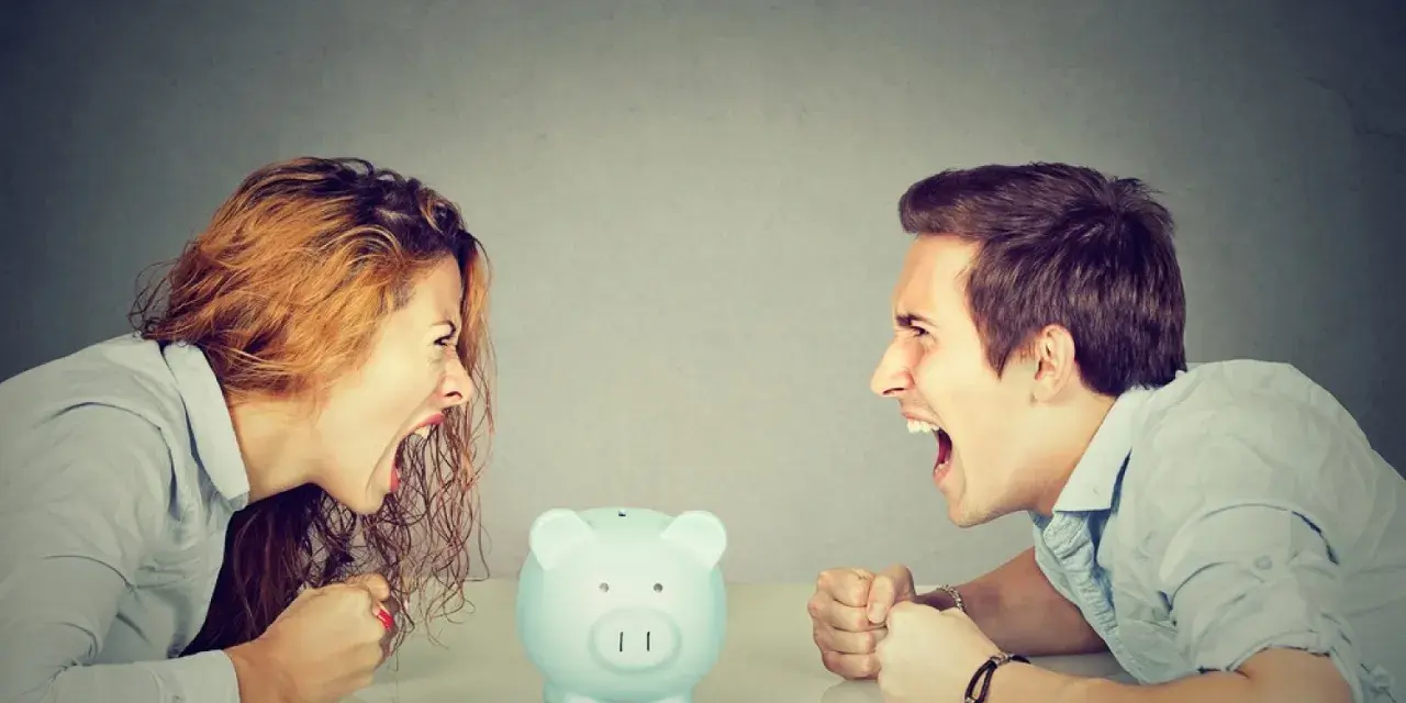 Un couple se crie dessus, poings serrés, devant une tirelire. Un vrai vol entre époux, la dispute pour l'argent est intense.