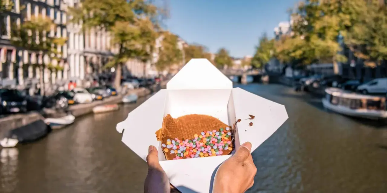 Un delizioso stroopwafel con zuccherini colorati, perfetto da gustare passeggiando lungo i canali di Amsterdam. Ecco cosa mangiare ad Amsterdam!