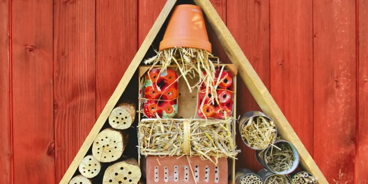 Ein Insektenhotel mit verschiedenen Materialien wie Holzscheiten, Stroh und Tonscherben. Hier finden Insekten ein Zuhause und Brutstätte.