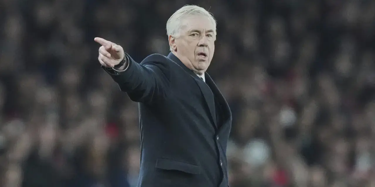 Carlo Ancelotti, con su característico gesto, señala algo en el campo.