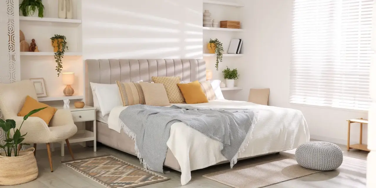 Dormitorios cálidos y acogedores con cama grande, sillón cómodo, plantas y estanterías decoradas.