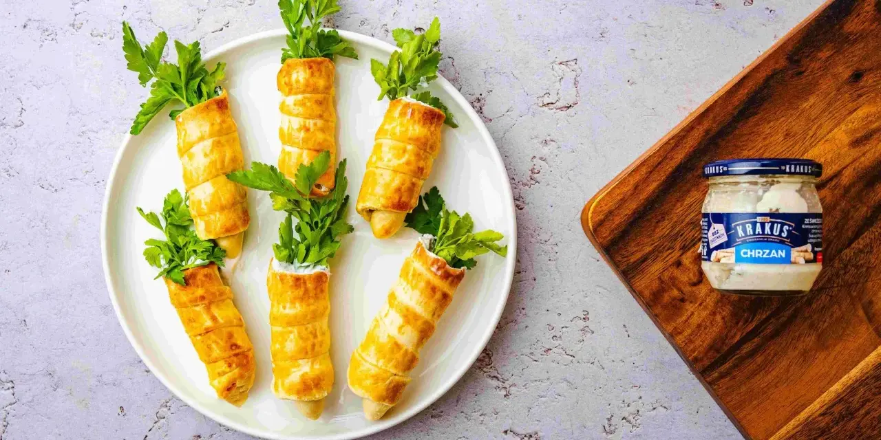 Urocze przekąski na Wielkanoc w kształcie marchewek, zawinięte w ciasto francuskie, z natką pietruszki i chrzanem Krakus.