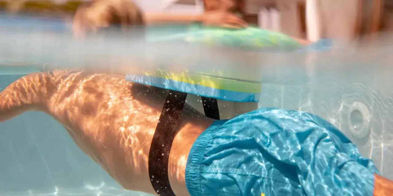 Plongeon sous-marin avec un dispositif de sécurité pour piscine, rappelant l'importance de la sécurité piscine réglementation pour tous.