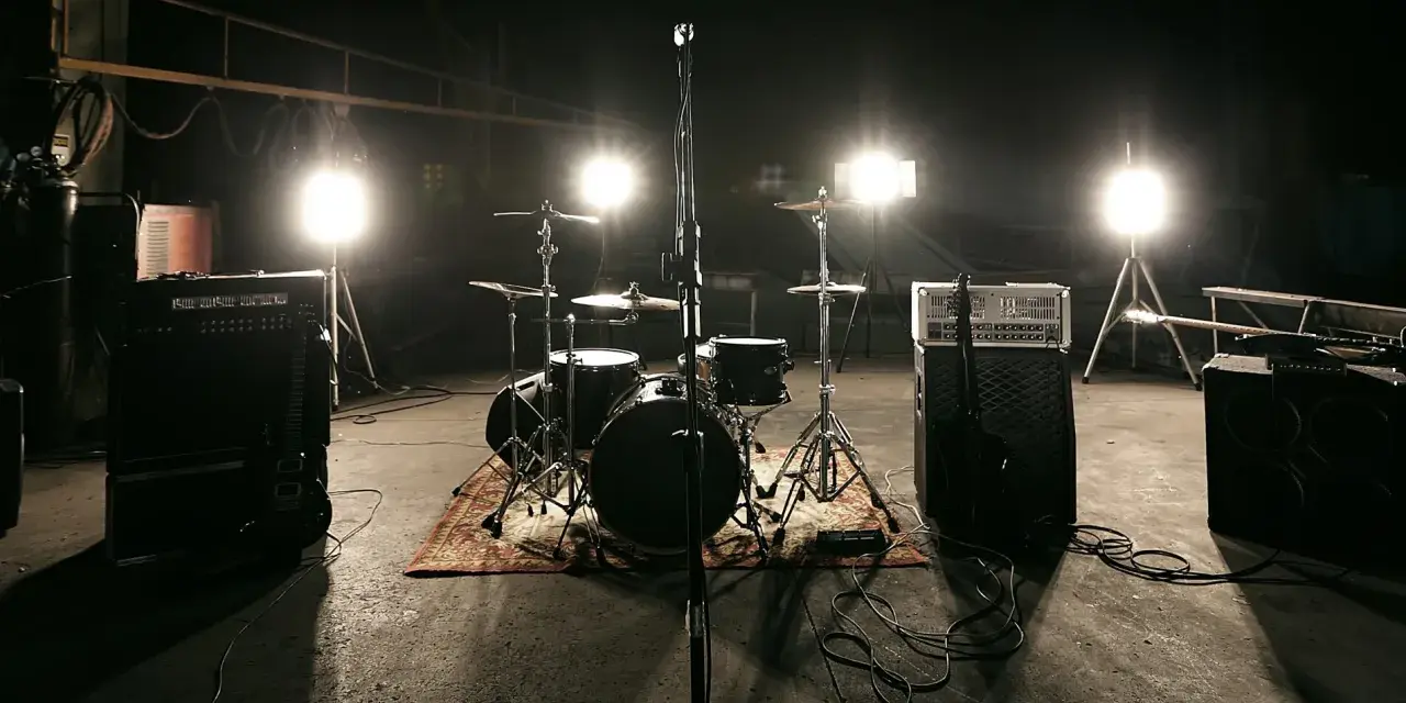 Scena z perkusją i wzmacniaczami, gotowa na koncert unplugged. Co to znaczy? To muzyka bez prądu, czysta energia!
