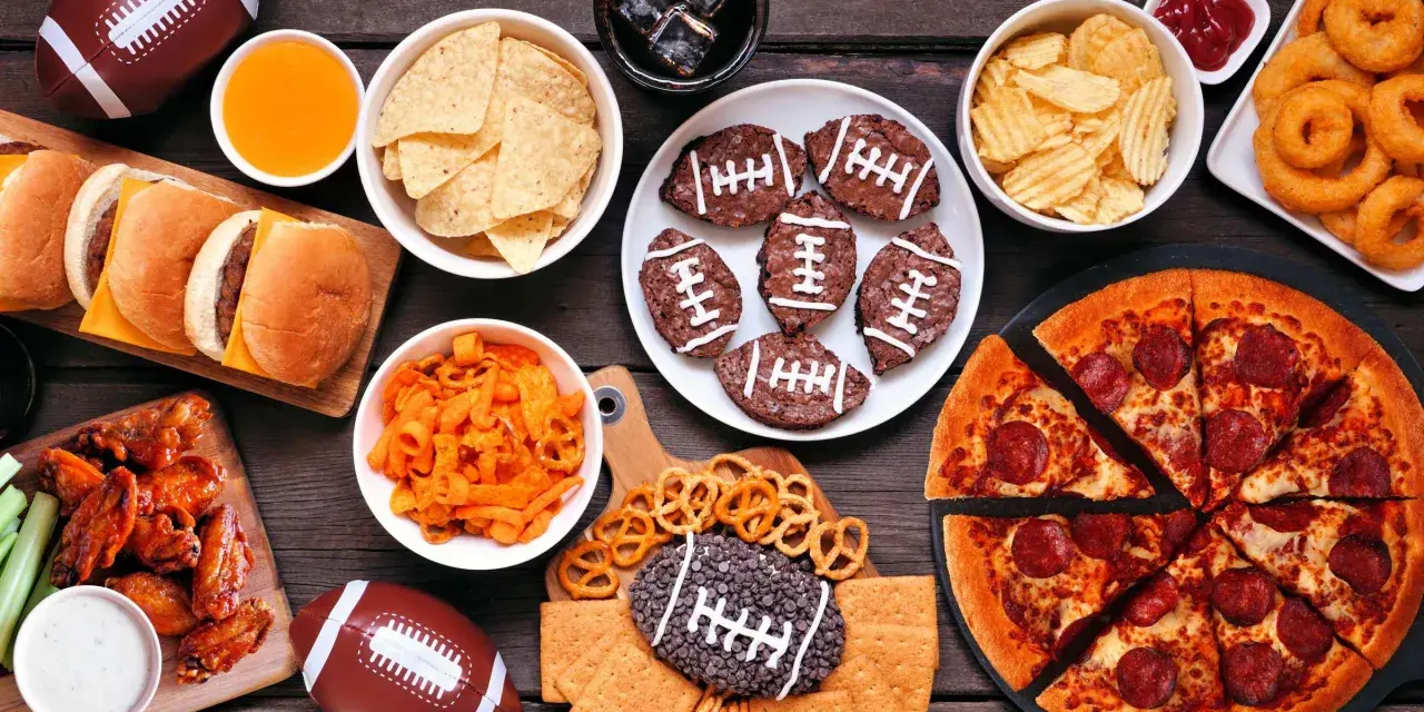 Perfekte Super Bowl Snacks: Pizza, Chicken Wings, Burger, Chips, Brownies in Football-Form und mehr.