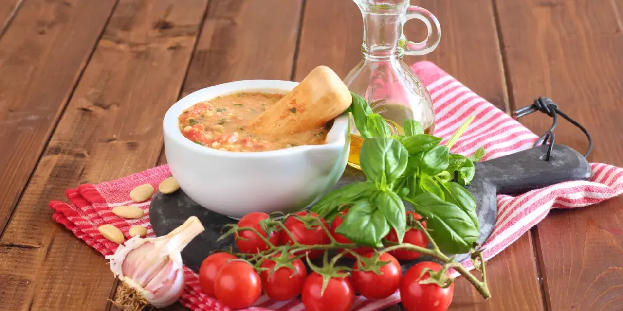 Mortai con pesto alla trapanese, pomodorini, basilico, aglio e mandorle, pronti per un sapore autentico.