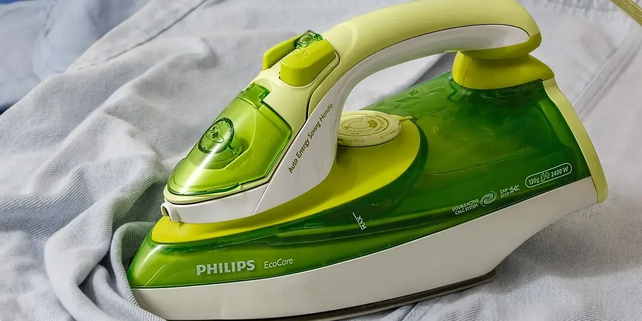 Ferro da stiro Philips EcoCare verde e giallo su un capo di abbigliamento. Non si vede a quanti gradi arriva il ferro da stiro.