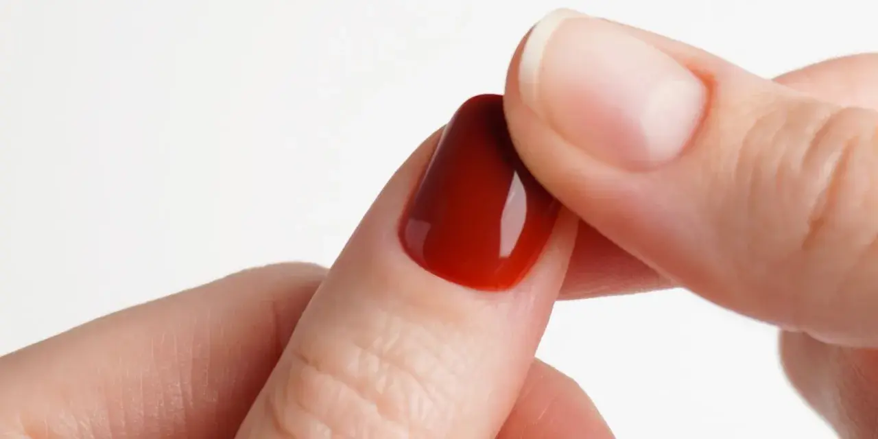 Dettaglio di un'unghia con smalto gel rosso intenso, perfetta per un tutorial unghie gel principianti.