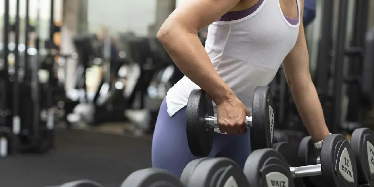En person lyfter en hantel, tränar sina typ 1 muskelfibrer i gymmet.
