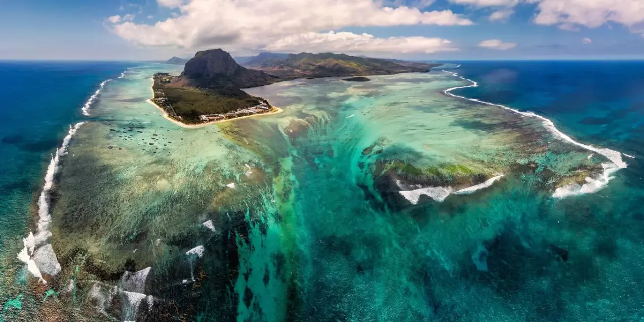 Niesamowity widok na Mauritius, gdzie podwodny wodospad tworzy iluzję spływającego piasku i mułu do głębin oceanu.