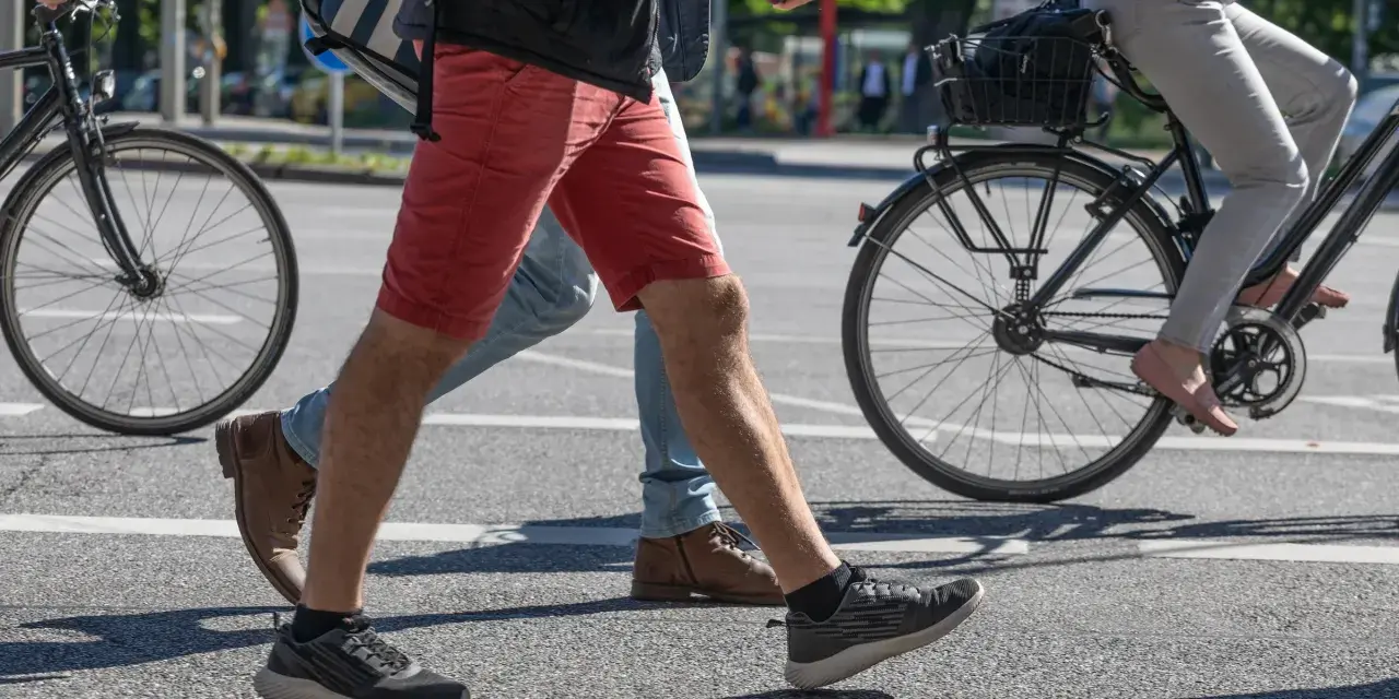 Ludzie idą i jadą na rowerze po mieście. Czy jazda na rowerze odchudza brzuch? Aktywność fizyczna pomaga spalać kalorie.