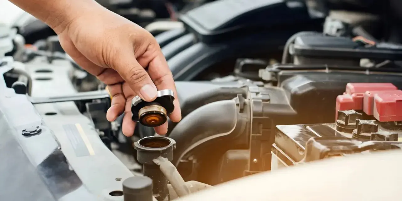 Hand removing radiator cap. This image might be relevant when researching radiator hose replacement cost.