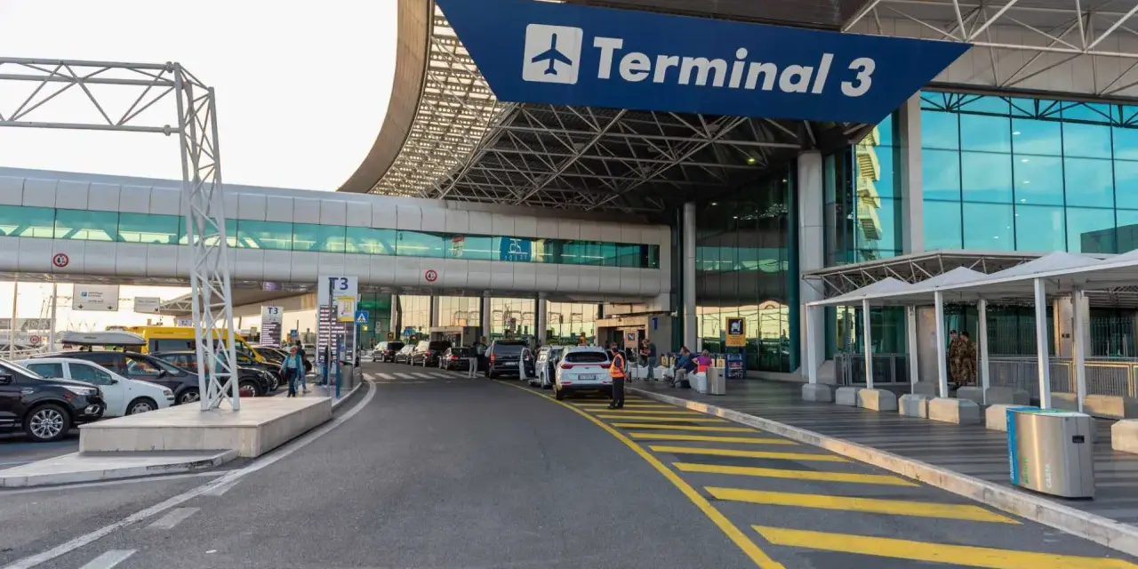 Wejście do Terminalu 3 lotniska Fiumicino z drogą dojazdową i samochodami.