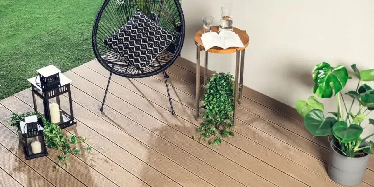 Drewno kompozytowe to świetny pomysł, czym wyłożyć balkon. Wygodne krzesło, stolik i rośliny tworzą przytulną przestrzeń.