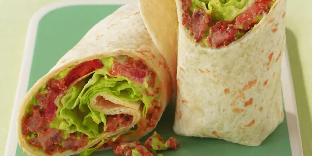 Zwei saftige wraps zum mitnehmen, gefüllt mit knackigem Salat, Tomaten und einer würzigen Fleischfüllung. Perfekt für unterwegs!