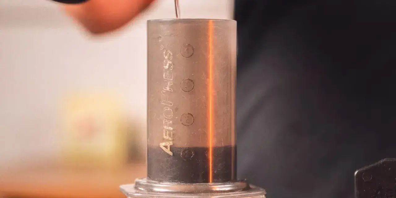 Przygotowanie kawy metodą aeropress cold brew. Woda powoli spływa do cylindra z kawą.