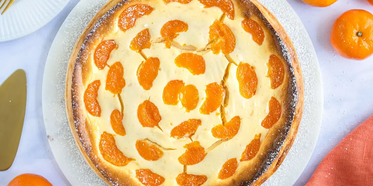 Ein goldbrauner, mit Mandarinen belegter Quarkkuchen, bestäubt mit Puderzucker. Dieser beste Mandarinen Quark Kuchen sieht köstlich aus!