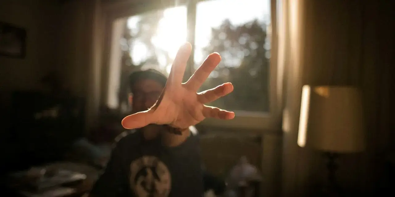 Dłoń wyciągnięta w stronę światła, jakby łapiąc promień słońca. To art 284, uchwycony w kadrze.
