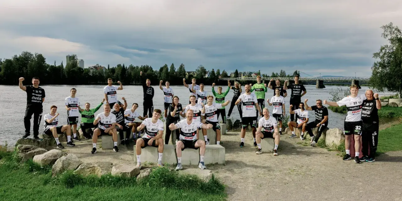 Drużyna Elverum Handball świętuje nad rzeką, pozując do wspólnego zdjęcia w sportowych strojach.