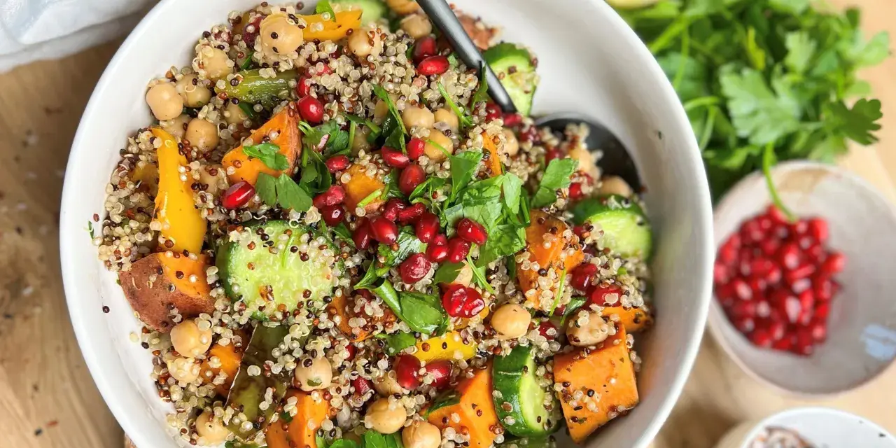 Bunter Quinoa-Salat mit Kichererbsen, Süßkartoffeln und Granatapfelkernen – eine köstliche Inspiration für proteinreiche Rezepte.