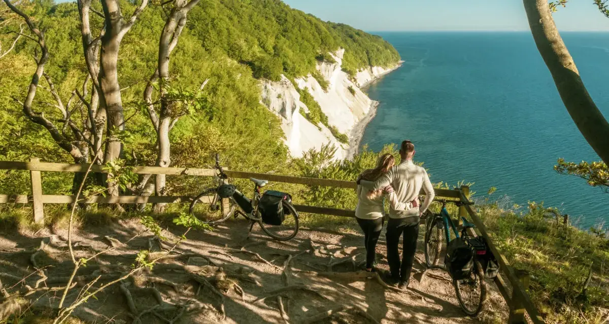 Para zakochanych podziwia widok na klify Møns Klint. Obok stoją rowery, gotowe do dalszej podróży.