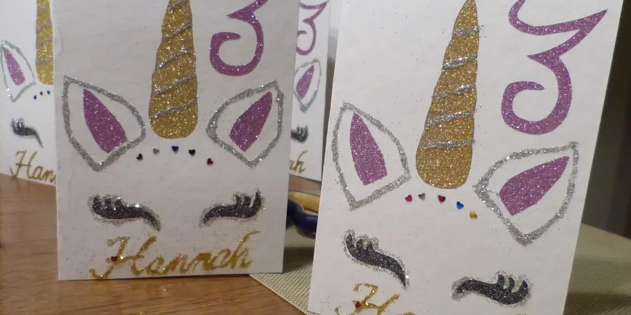 Glitzernde Einhorn-Einladungen zum 3. Geburtstag basteln. Hannahs Name ist in Goldbuchstaben geschrieben.