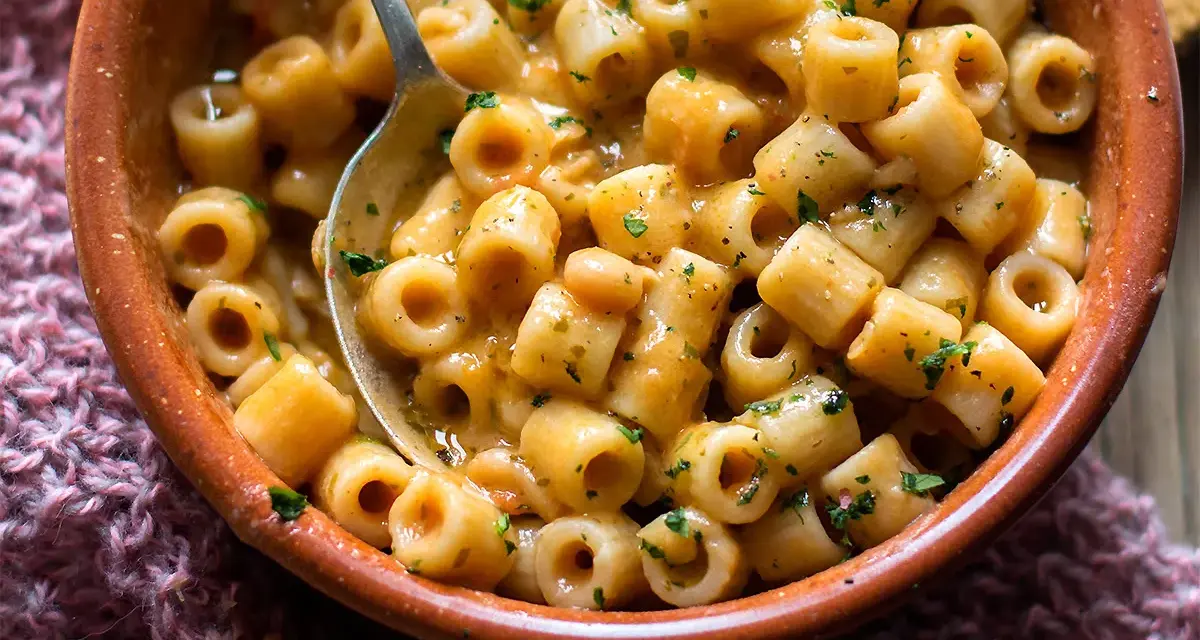 Un piatto fumante di pasta e fagioli, con ditalini e fagioli borlotti in un sugo cremoso, guarnito con prezzemolo tritato.