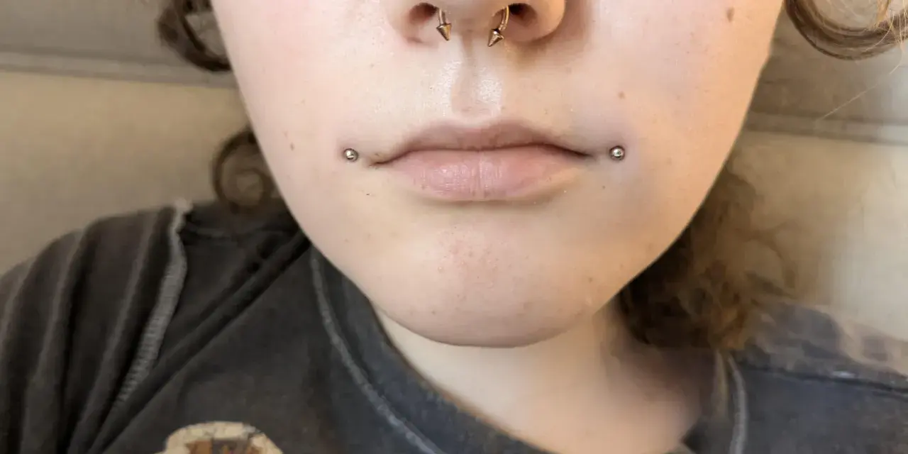 Dahlia piercing zdobi usta, dodając odrobinę buntu.