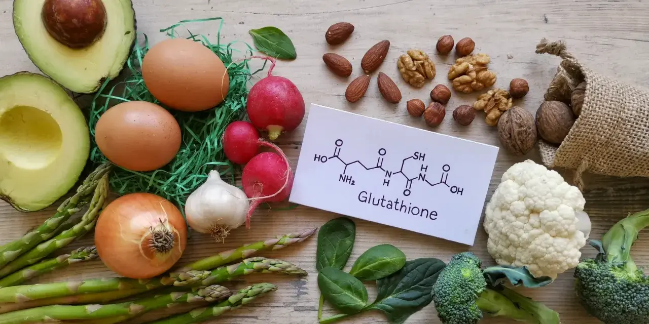 Glutation na co pomaga? Zdrowa żywność: awokado, jajka, warzywa, orzechy i wzór chemiczny glutationu.