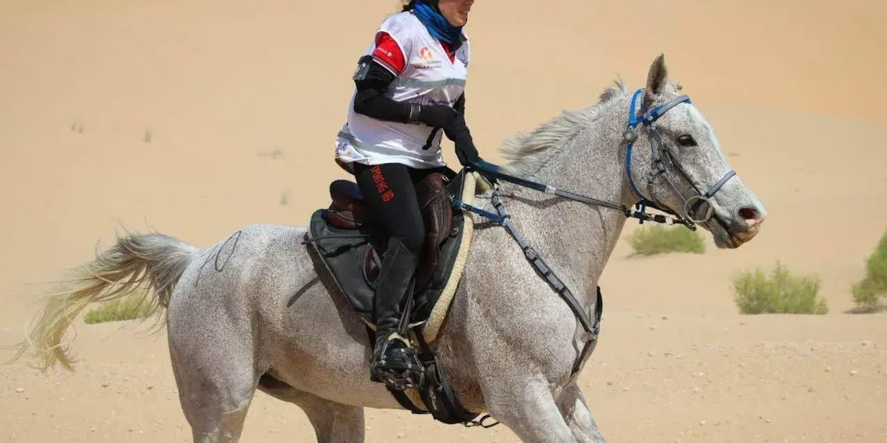 Une cavalière et son pur sang arabe endurance traversent le désert.