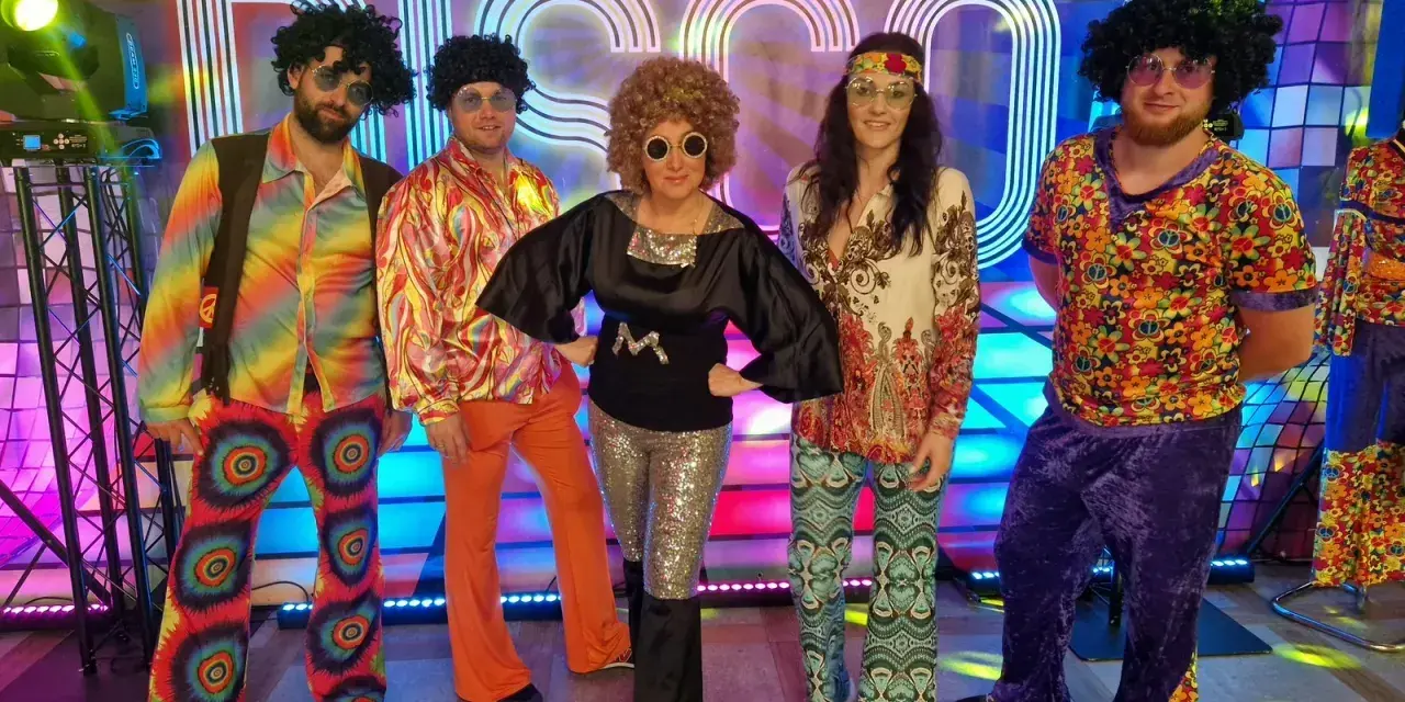 Grupa przyjaciół postanowiła się ubrać w stylu lat 90. na imprezę disco. Kolorowe stroje, peruki i błyszczące dodatki tworzą niezapomnianą atmosferę.