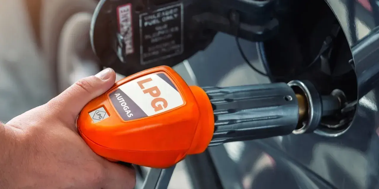 Tankowanie auta gazem LPG. Pomarańczowa dysza z napisem "AUTOGAS LPG" jest wkładana do baku pojazdu.