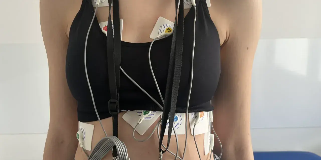 Osoba z elektrodami EKG przyczepionymi do klatki piersiowej i brzucha.