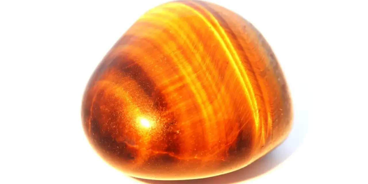 Piedra ojo de tigre pulida, con bandas doradas y marrones. Ideal para aprender como limpiar ojo de tigre y mantener su brillo.