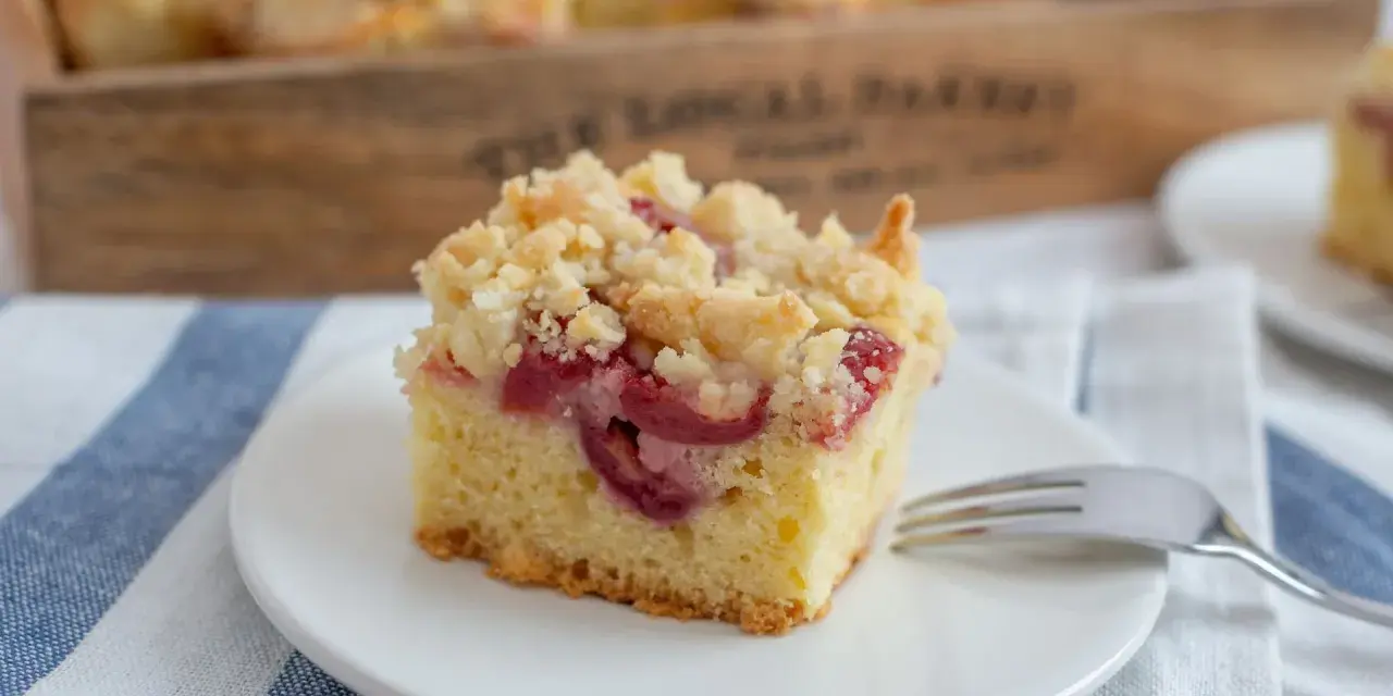 Ein Stück Kirsch-Streuselkuchen, perfekt für ein einfaches Crumble Rezept. Saftige Kirschen unter knusprigen Streuseln.