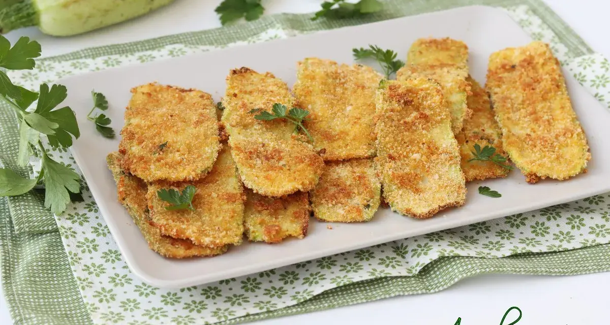 Cotolette di zucchine dorate e croccanti, guarnite con prezzemolo fresco. Un contorno sfizioso e leggero.