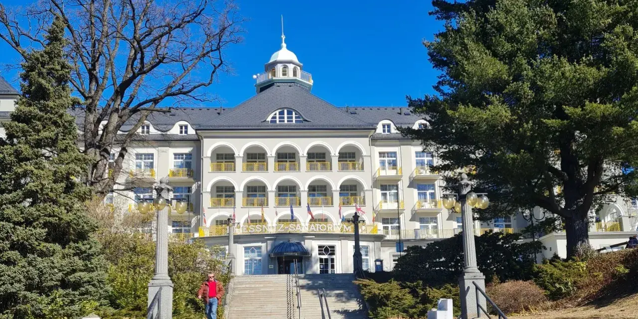 Piękny budynek sanatorium w Jeseniku, z charakterystycznymi arkadami i żółtymi balustradami. To jedna z głównych atrakcji regionu.