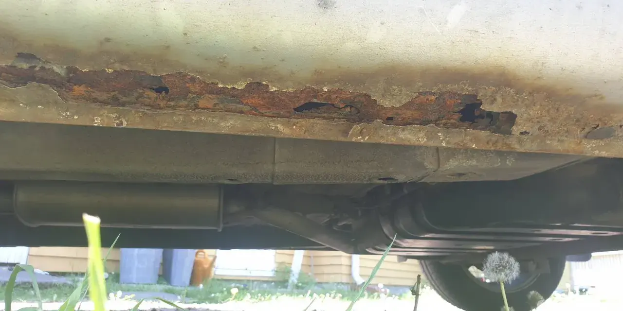 Kraftig rost på bilens tröskel, hål syns. Dags att laga rost bil innan det blir värre.