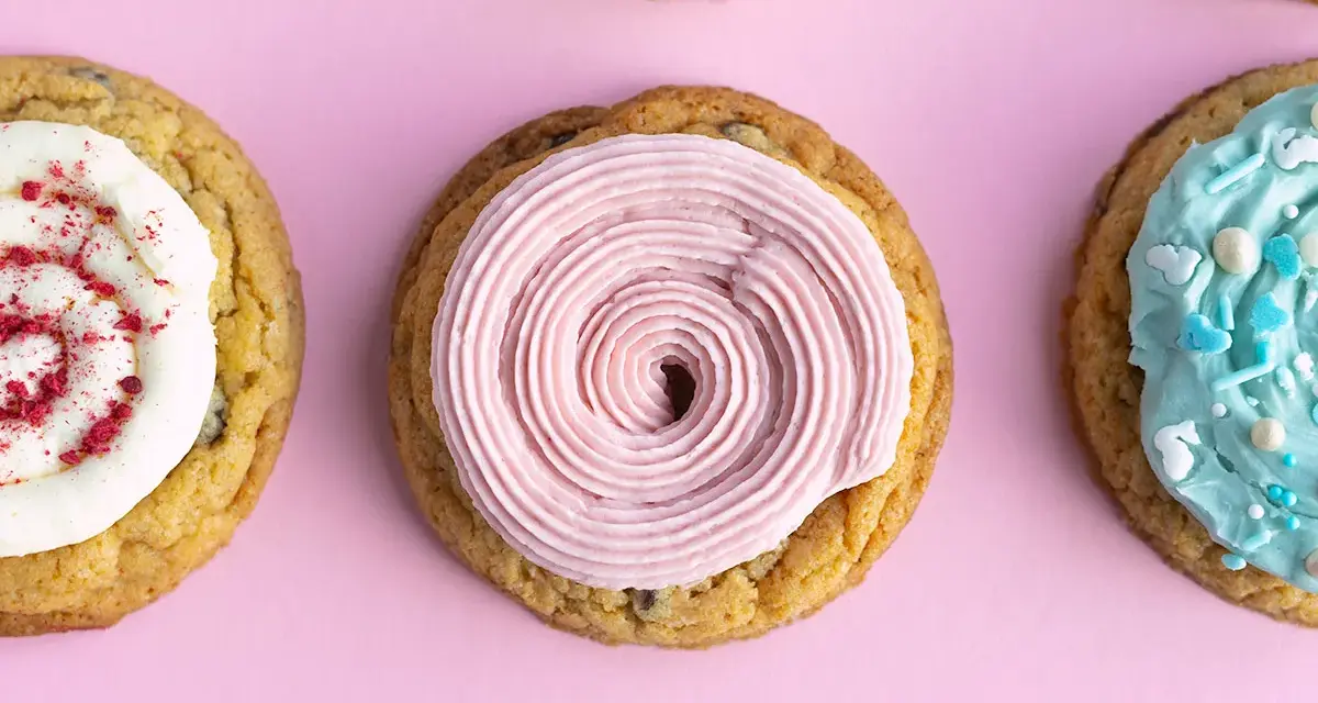 Galletas americanas decoradas con glaseado rosa, blanco con frambuesa y azul con chispas. ¡Una deliciosa receta para compartir!
